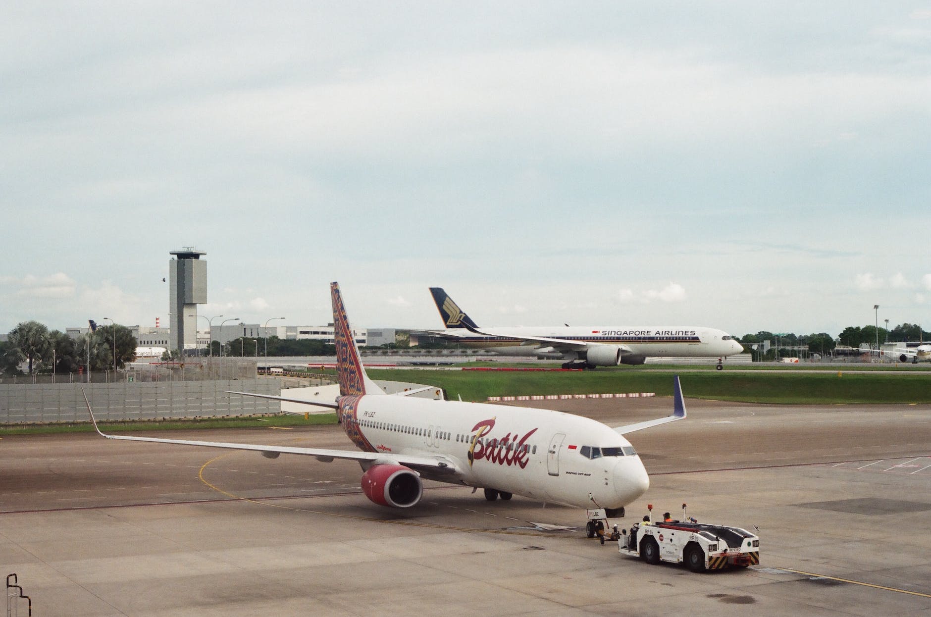 an airplane with tug on the runway