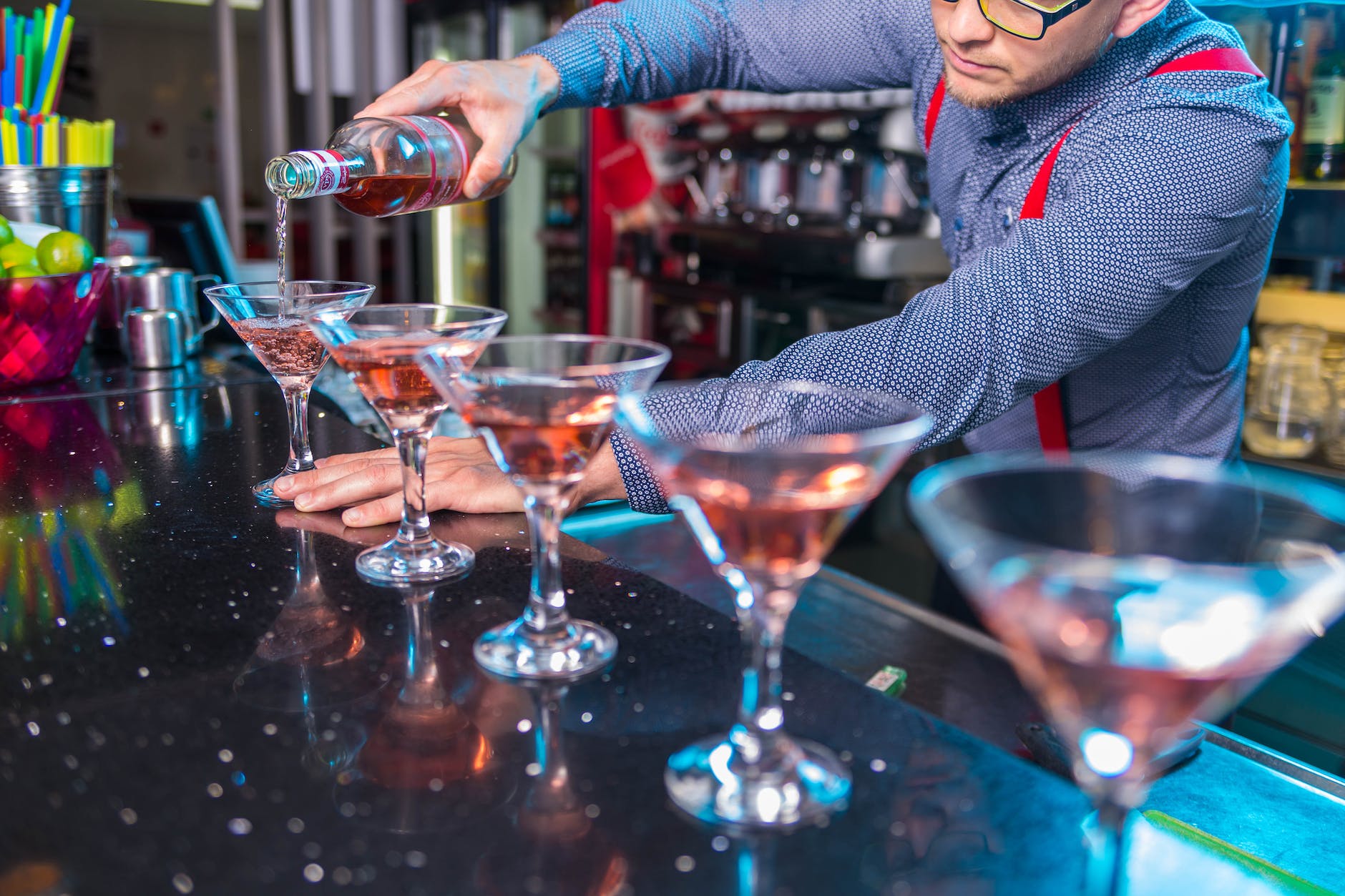 photo of man pouring liqueur on glass