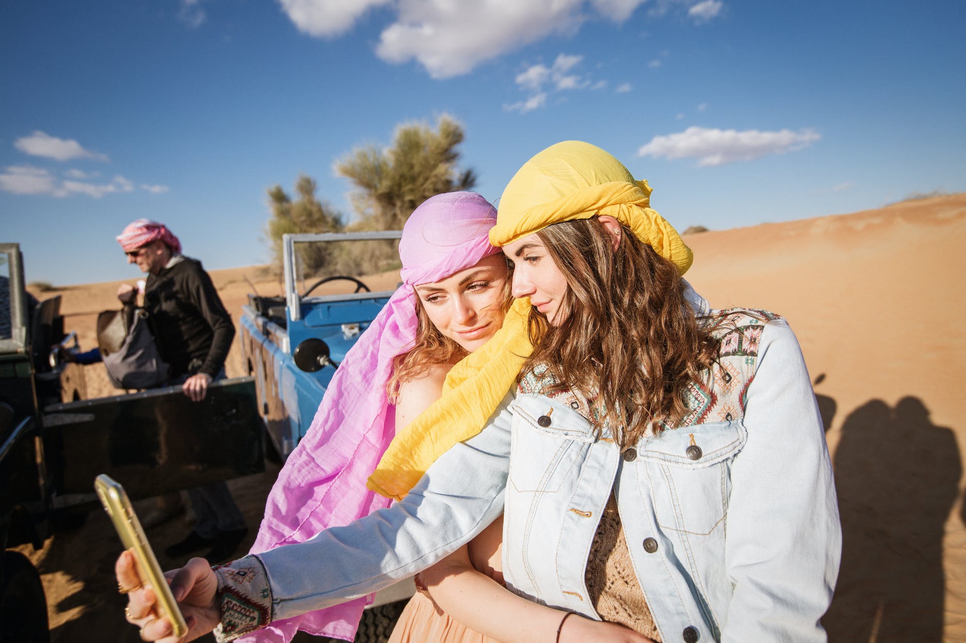 two women wearing head scarf taking selfie together
